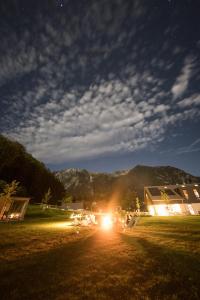 un grupo de personas sentadas en un campo por la noche en The Campus Alps - tiny homes, en Hieflau