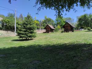 due gazebo in un campo con un albero di Mini-Camp SKELICA a Neštin