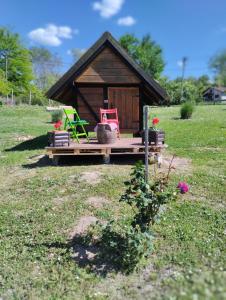 mały dom z gankiem i dwoma krzesłami w obiekcie Mini-Camp SKELICA w mieście Neštin