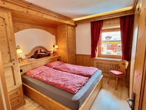 um quarto com uma cama e uma janela em Bike&Ski Saroch Apartments em Livigno