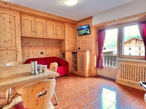 uma sala de estar com um sofá vermelho e uma janela em Bike&Ski Saroch Apartments em Livigno