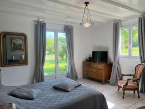 a bedroom with a bed and a mirror and a chair at L'Ariade in Monpazier