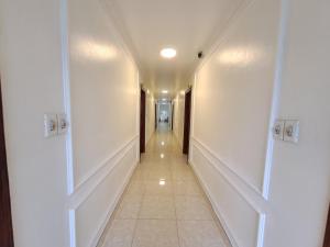 a hallway with white walls and a long hallway at HTC Hotel Tuần Châu Island in Ha Long