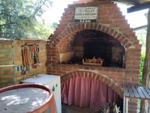 a brick oven with a table and a sign on it at Mini-Camp SKELICA in Neštin