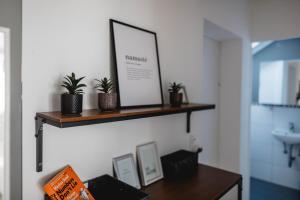 a shelf with plants and a picture on a wall at ME Homes - große moderne Designer-Wohnung für Urlaub und Business - mit Küche, Büro, Balkon und 2 Parkplätzen in Bayreuth +16 photos