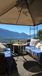 eine Terrasse mit 2 Betten und einem Tisch mit Aussicht in der Unterkunft Pensione Olanda in Locarno