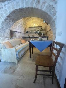 a bedroom with a bed and a table in a brick wall at AL 13 in Alberobello