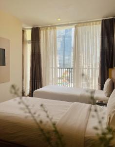 a hotel room with two beds and a large window at GK Central Hotel in Ho Chi Minh City