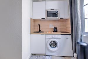 a kitchen with a washing machine and a microwave at Wisdom at heart in Périgueux +9 photos
