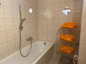 a bathroom with a tub and a shower with orange towels at Appartment Maxi 3 Personen, Zentrale Lage, ruhige Nebenstraße in Dessau +27 photos