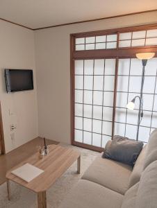 sala de estar con sofá y mesa de centro en KIBA HOUSE, en Tokio