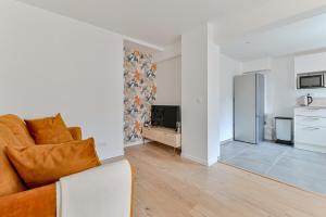 sala de estar con sofá y cocina en Appartement cosy proche de Paris, en Bagnolet