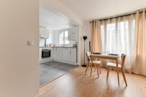 cocina con mesa y sillas en una habitación en Appartement cosy proche de Paris, en Bagnolet