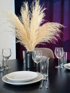 a black table with plates and glasses on it at UNIQUE Apartment with parking in Toruń +29 photos