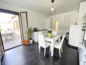 a kitchen and dining room with a white table and chairs at TEA&CHILL - Manhattan home - proche gare in Tremblay En France