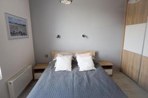 een slaapkamer met een bed met 2 kussens bij Apartament Kapitański in Pogórze