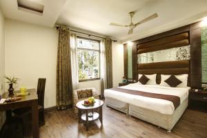 a hotel room with a bed and a desk and a window at Hotel Good Times Near Metro in New Delhi
