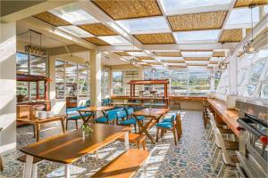 a restaurant with wooden tables and chairs and windows at Horison Resort Dieng in Kejajar