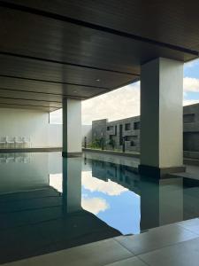 a swimming pool with some chairs and a building at Hotel101 - Fort in Manila