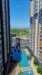 - une vue aérienne sur une piscine située entre deux grands bâtiments dans l'établissement K Avenue home Suhaila, à Kota Kinabalu