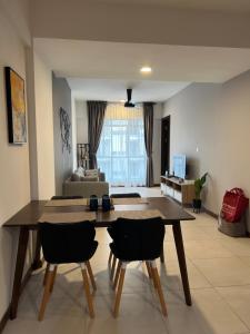 un salon avec une table et des chaises en bois dans l'établissement K Avenue home Suhaila, à Kota Kinabalu