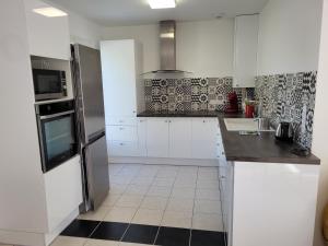 a kitchen with white cabinets and a black counter top at Maison sur ile d'Oléron in Saint-Pierre-dʼOléron