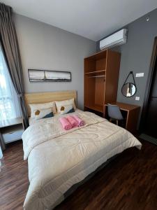 - une chambre avec un grand lit et 2 oreillers roses dans l'établissement K Avenue home Suhaila, à Kota Kinabalu
