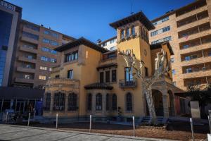 un edificio giallo con un albero di fronte di Globales Castillo de Ayud a Calatayud