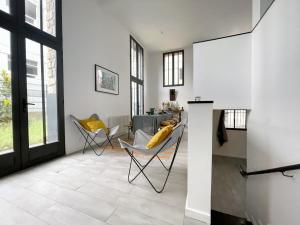 a living room with yellow chairs and a table at TEA&CHILL - Nice Triplex Loft - with garden in Montreuil