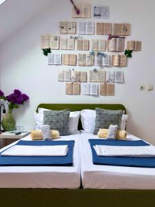 a bedroom with a bed with books on the wall at Casa Trandafirilor in Tulcea