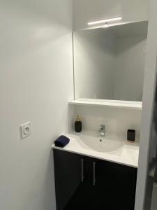 a bathroom with a sink and a mirror at Flat Bobigny near Paris 1 min from the metro in Bobigny