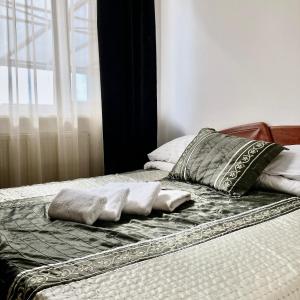 a bed with two pillows on top of it at Hotel Nostalgia in Senec