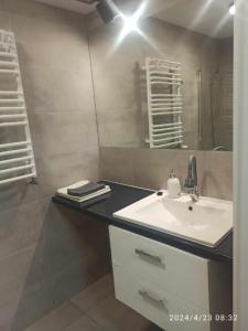 a bathroom with a sink and a mirror at Krynica - pokoje in Krynica Morska