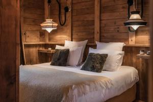 une chambre avec un lit avec des draps blancs et des oreillers dans l'établissement Chalet Mathilda - Les Chalets COVAREL, à Val dʼIsère 31 autres photos