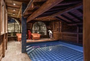 une maison avec piscine dans une chambre dotée de plafonds en bois dans l'établissement Chalet Mathilda - Les Chalets COVAREL, à Val dʼIsère