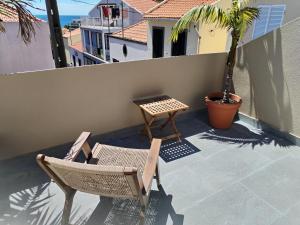 un patio con 2 sedie e un tavolo sul balcone di Casa do Favinha a Machico