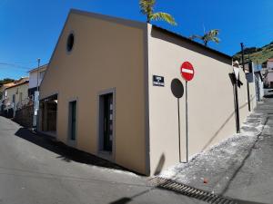 un edificio bianco con un cartello di stop accanto a una strada di Casa do Favinha a Machico