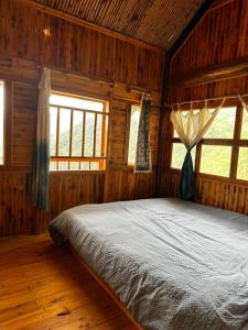 sypialnia z łóżkiem w drewnianym pokoju w obiekcie Sapa Wind’s House w mieście Lao Cai