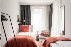 a bedroom with a bed and a chair and a window at Lion Apartments - SCALA City Center Premium Apartments&Studio IID in Gdańsk