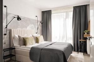 a bedroom with a bed and a large window at Lion Apartments - SCALA City Center Premium Apartments&Studio IID in Gdańsk