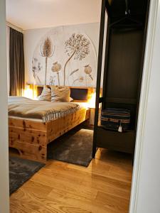 una camera da letto con un letto e un dipinto sul muro di Grünseeappartement a Turracher Hohe