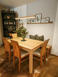 a dining room table with chairs and a christmas tree at Grünseeappartement in Turracher Hohe