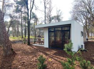 een klein wit huis in het bos bij Natuurhuisje Hellendoorn in Haarle