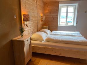 a bed in a room with a window at Farmhouse with a stunning view over the dolomites in Villnoss