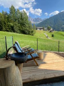 a bench on a wooden deck with a view of a mountain at Farmhouse with a stunning view over the dolomites in Villnoss