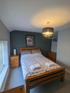 - une chambre avec un grand lit et un lustre dans l'établissement Blue Bell Apartment, à Kidsgrove