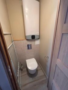 łazienka z toaletą z telewizorem na ścianie w obiekcie Charmant appartement F1 w mieście Saint-Dizier