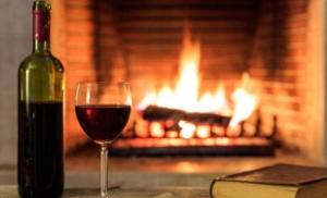 a glass of wine sitting next to a fireplace at Gallery Guesthouse (La Sky Villa) in Gqeberha