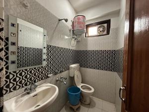 La salle de bains est pourvue d'un lavabo, de toilettes et d'un miroir. dans l'établissement Mountain Trail, à Dharamshala