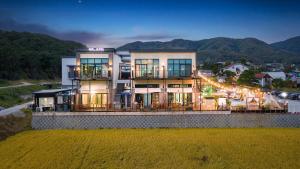 a large building with lights on in front of a mountain at Majoong Pool Villa Pension in Gyeongju